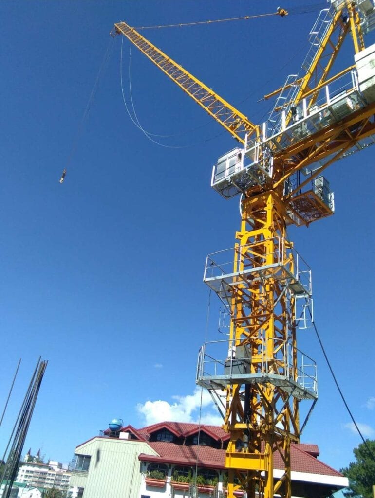 Guindaste amarelo em construção sob céu azul claro.
